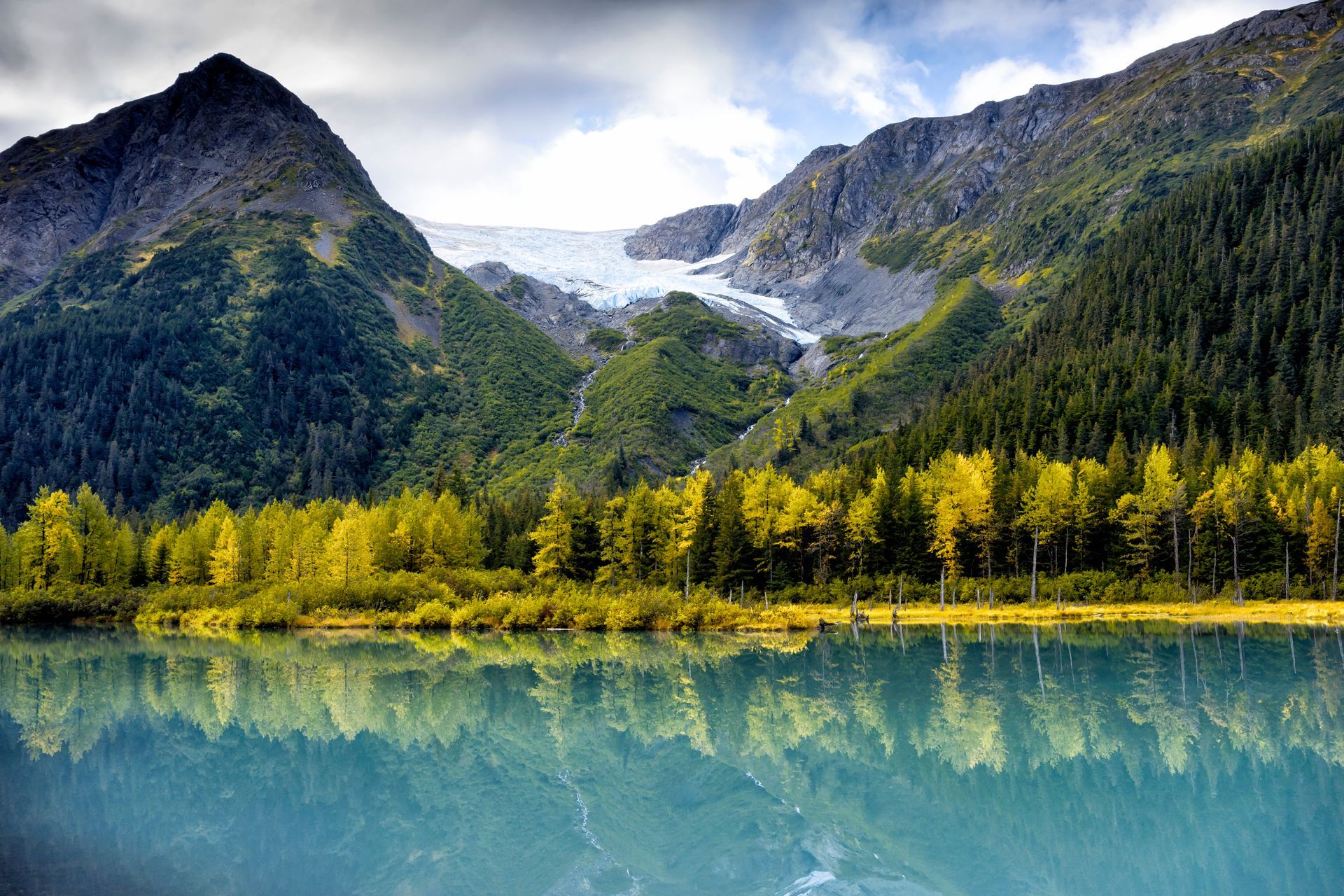 Turquoise glacier-fed lake below Alaskan mountains in autumn