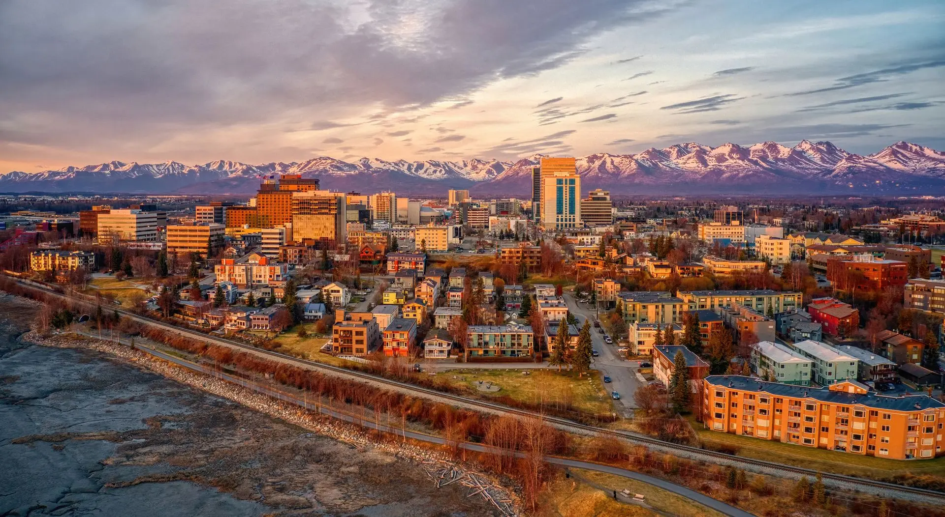Aerial view of downtown Anchorage at sunrise with the Chugach range behind it
