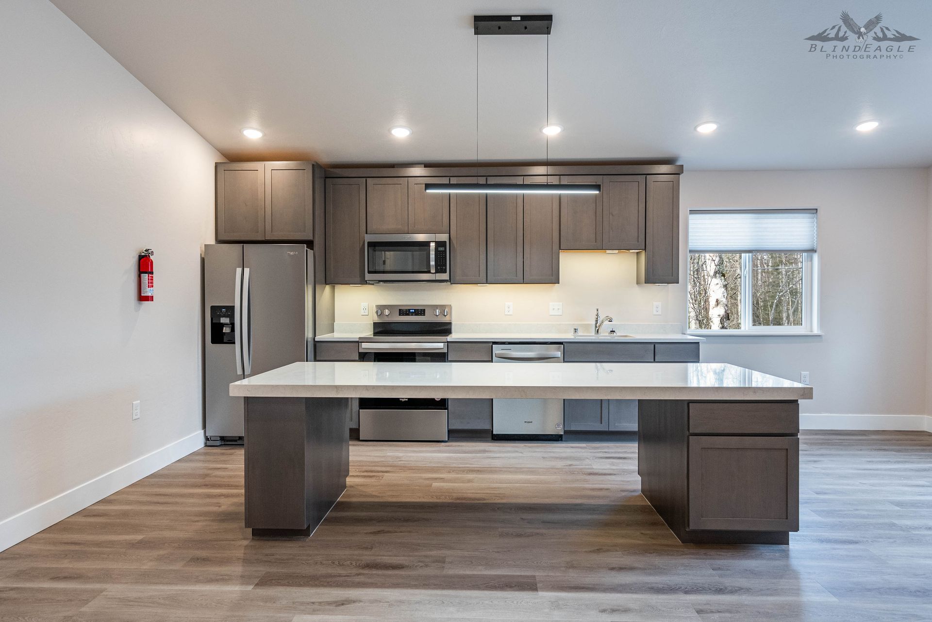 Bright modern rental kitchen with a large quartz island and stainless appliances